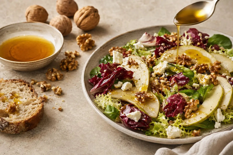 Walnut oil drizzled over pear, walnut and goat cheese salad